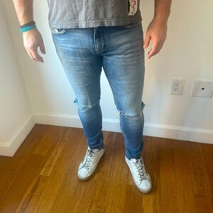 Men’s slim blue Diesel jeans with cut outs at the knees, size 31